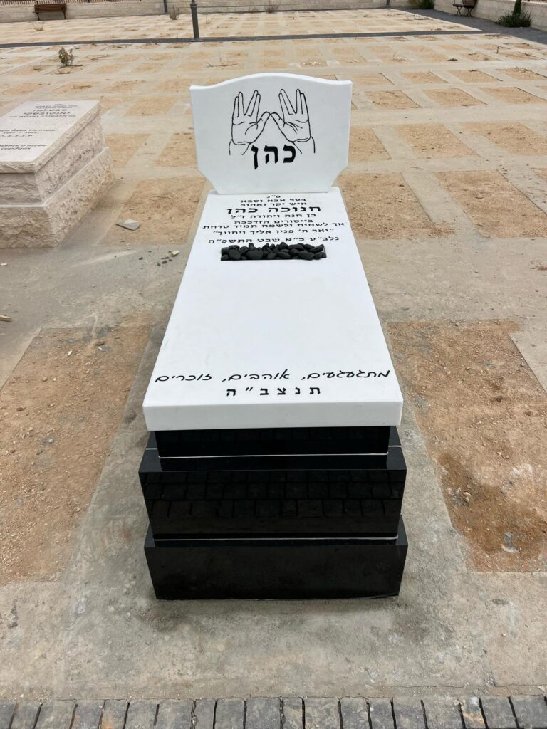 מצבת כהן מעוצבת משיש טסאסוס לבן עם בסיס גרניט שחור בצפון הארץ, כוללת סמל כפיים חרוט בראש המצבה.