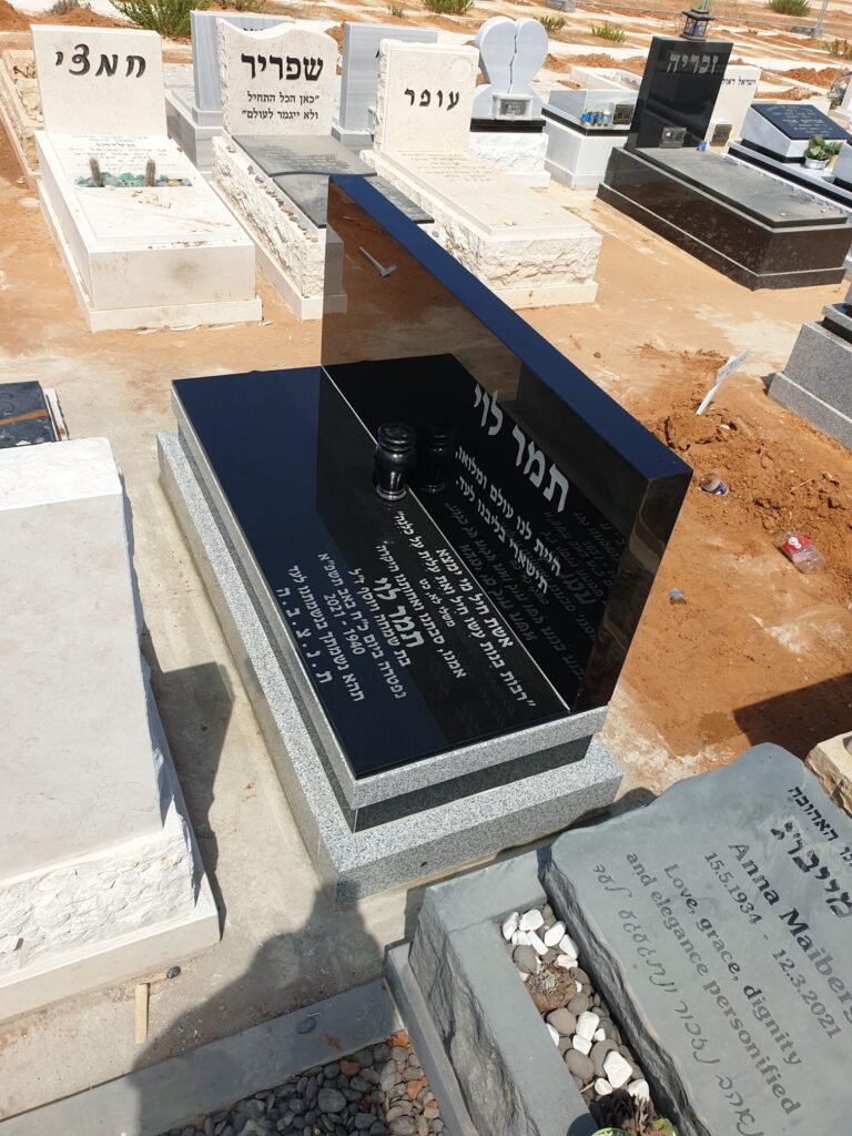 מצבת גרניט שחור בעיצוב מודרני ומוקפד, עם חזית אנכית מעוצבת וכיתוב לבן בולט, ממוקמת במרכז הארץ.